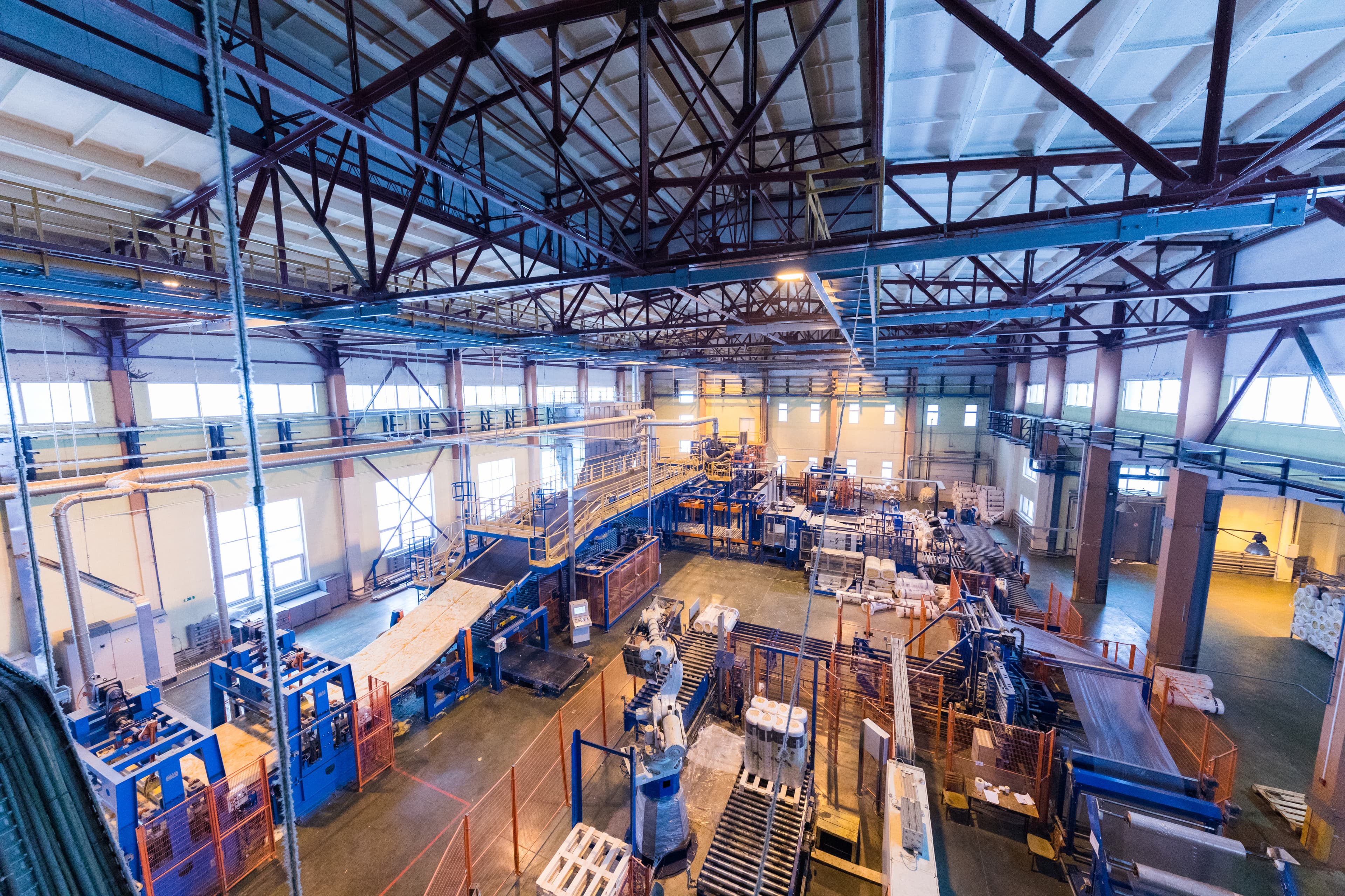 Interior da fábrica com máquinas e linhas de produção
